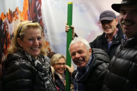 Gäste lachen am Fotopunkt vor der Bergkulisse.