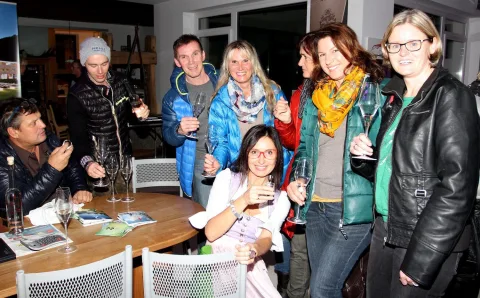 Gäste verfolgen die Verlosung an einem runden Tisch.