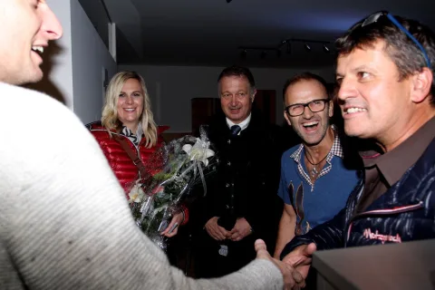 Gratulation mit Blumenstrauß im Verkaufsraum.