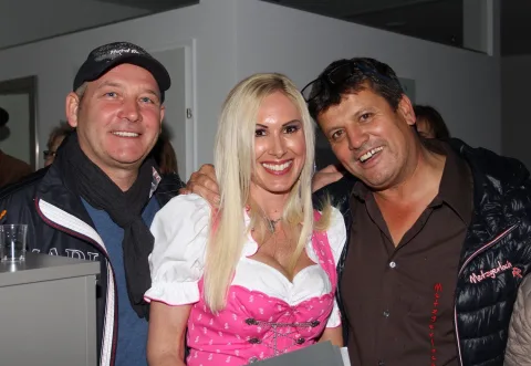 Zwei Gäste mit der Hostess in Tracht.