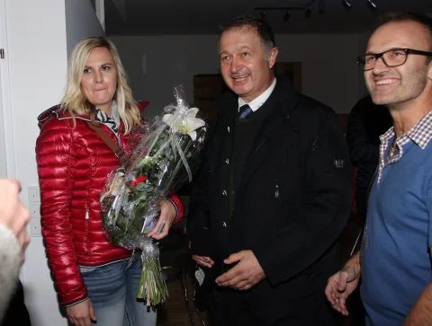 Drei Gäste im Verkaufsraum, eine mit Blumenstrauß.