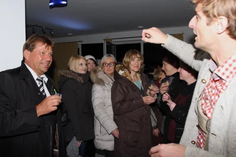 Ein Gast erklärt etwas vor einer Gruppe im Verkaufsraum.