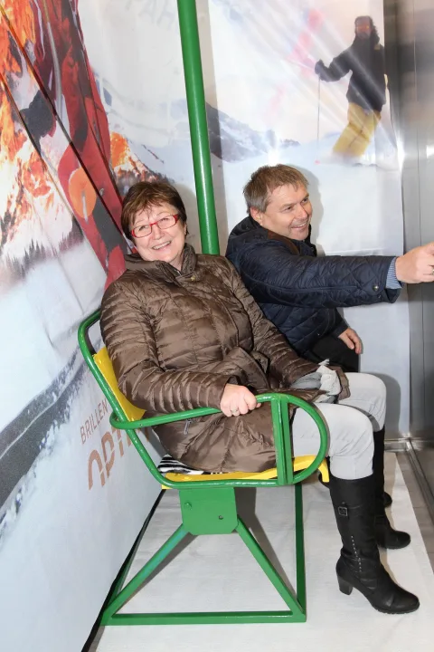 Ein Paar sitzt im Sessellift des Fotopunkts.
