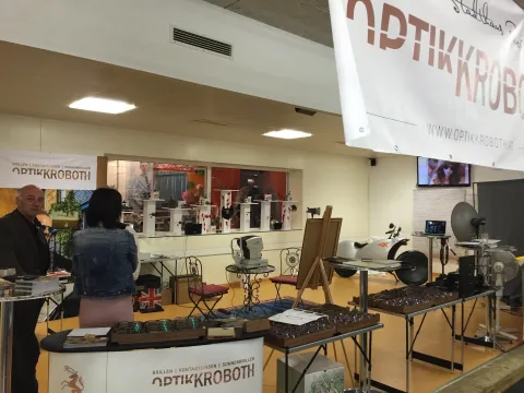Der Messestand mit Banner, Präsentationstischen und Besuchern im Autohaus