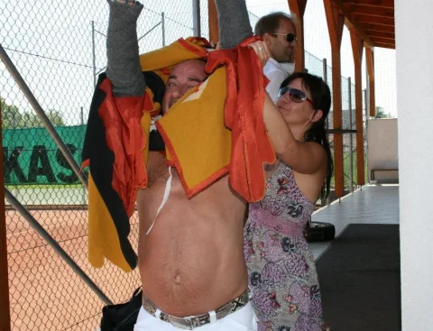 Zwei Personen mit einer Fahne vor einem Zaun