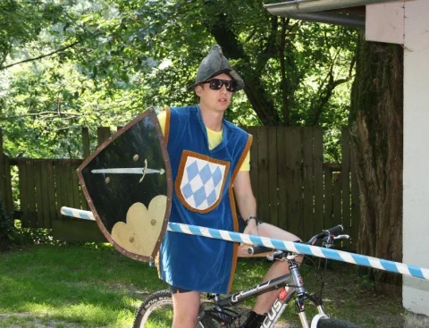 Ein Mann im Ritterkostüm fährt Fahrrad