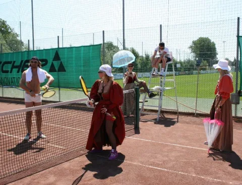 Eine Gruppe von Menschen spielt Tennis auf einem Tennisplatz