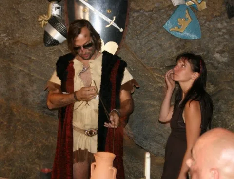 Ein Darsteller im Lederwams und eine Frau vor einer Steinwand