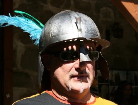 Ein Mann mit Helm, Federbusch und Sonnenbrille im Profil