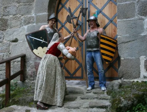 Zwei Darstellerinnen mit Schild und Speer vor dem Holztor