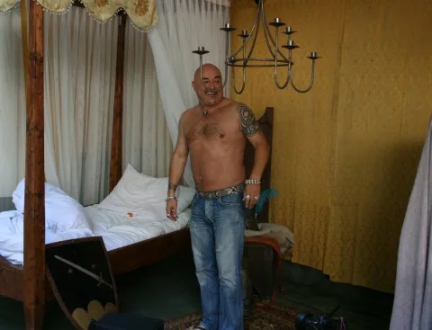 Ein Mann in einem Raum mit Himmelbett und gelber Wand