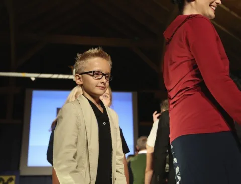 Ein Junge mit Brille auf dem Laufsteg