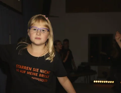 Ein Mädchen mit Brille im Shirt der Aktion