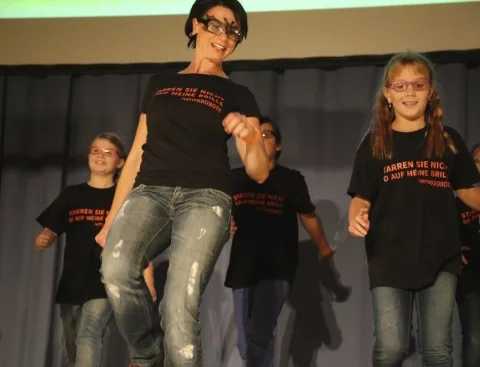 Eine Erwachsene und zwei Kinder auf der Bühne
