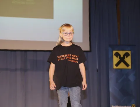 Ein Mädchen mit Brille auf der Bühne