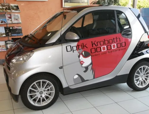 Ein Kleinwagen mit Optik-Kroboth-Beschriftung im Ausstellungsraum