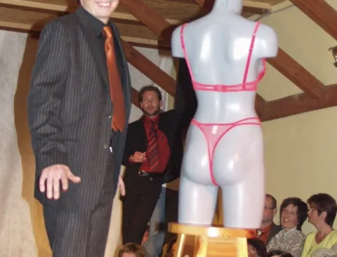 Ein Model im Nadelstreifenanzug neben einer Schaufensterpuppe mit Dessous
