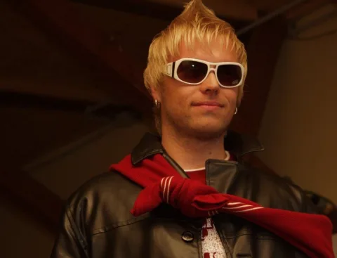 Nahaufnahme eines Models mit weißer Sonnenbrille und rotem Halstuch