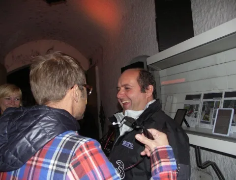 Zwei Besucher im Gespräch vor einer beleuchteten Brillenvitrine