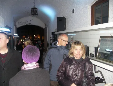 Besucher im Gespräch vor einer Vitrine, im Hintergrund der Gewölbegang