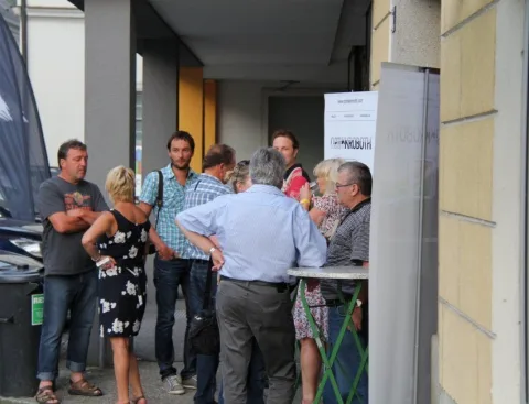 Besucher an Stehtischen in einem hellen Raum