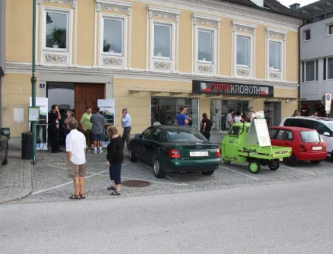 Blick auf die Straße vor dem Geschäft mit dem grünen Kleintransporter