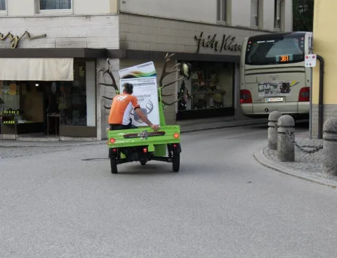 Der grüne Kleintransporter fährt durch die Straße
