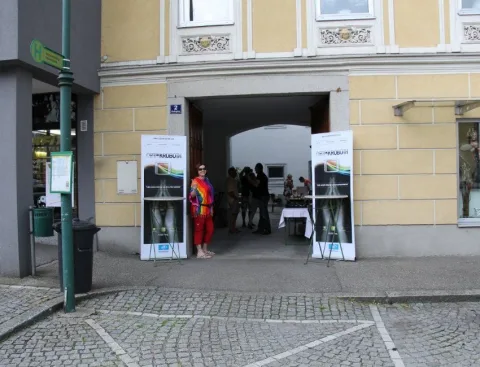 Blick durch ein Tor auf Aufstellwände und Besucher