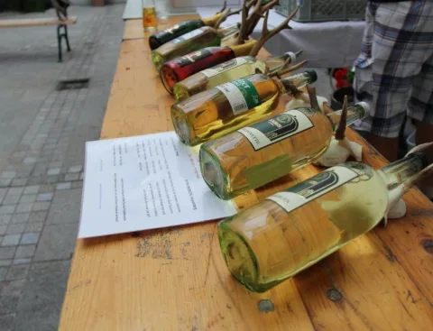 Weinflaschen liegen auf einem Holztisch neben einer Liste