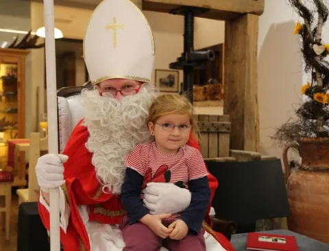 Der Nikolaus mit einem Mädchen vor der Fassungswand