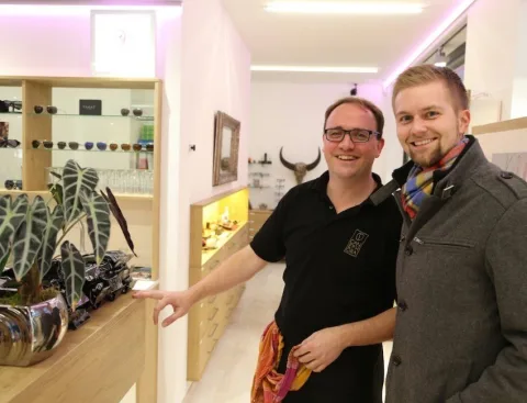 Zwei Männer an einer Vitrine, einer zeigt auf die Auslage