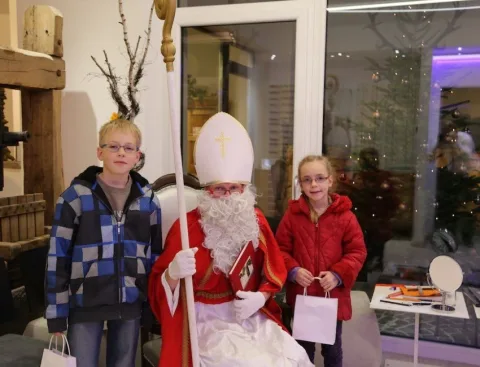 Der Nikolaus mit zwei Kindern und Geschenktüten
