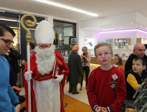 Ein Junge vor dem Nikolaus, dahinter weitere Besucher