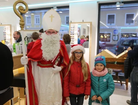 Der Nikolaus mit zwei Mädchen vor dem Fenster