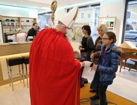 Der Nikolaus reicht einem Jungen eine Tüte