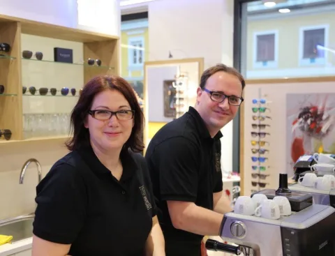 Zwei Mitarbeitende an der Kaffeemaschine