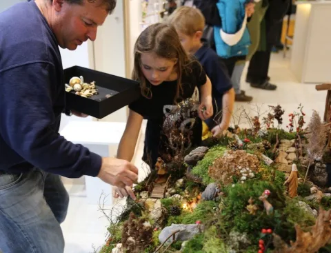Ein Mann und Kinder an der Weihnachtsdekoration