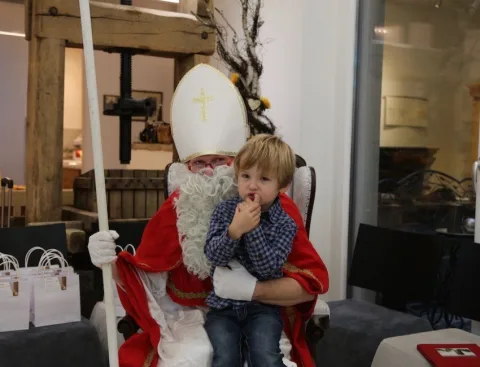 Der Nikolaus mit einem kleinen Jungen auf dem Schoß