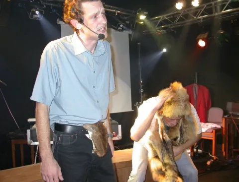 Ein Darsteller mit Mikrofon auf der Bühne