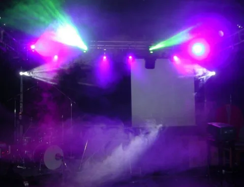 Die leere Bühne im violetten Scheinwerferlicht und Nebel