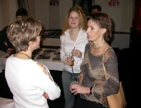 Drei Besucherinnen am Brillentisch vor dem Rey-Schriftzug