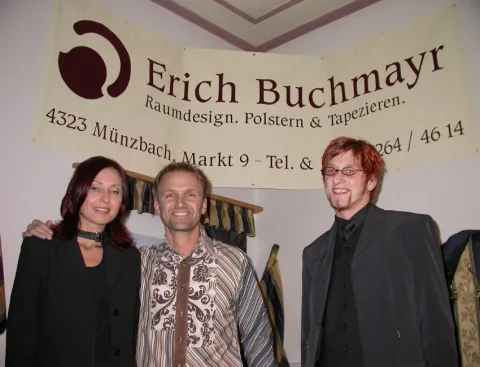 Drei Gäste vor einem Banner eines Raumausstatters