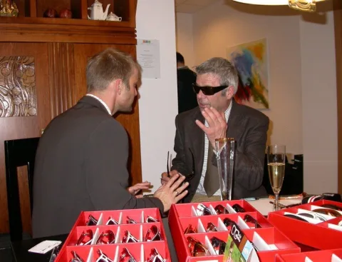 Ein Gast probiert eine Sonnenbrille am Verkaufstisch