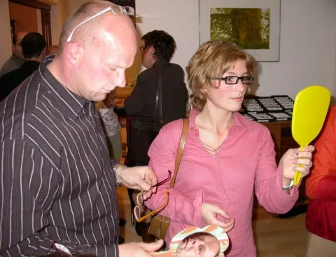 Zwei Gäste mit Handspiegeln beim Anprobieren