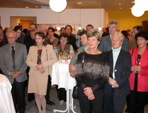 Gäste an Stehtischen im hellen Raum