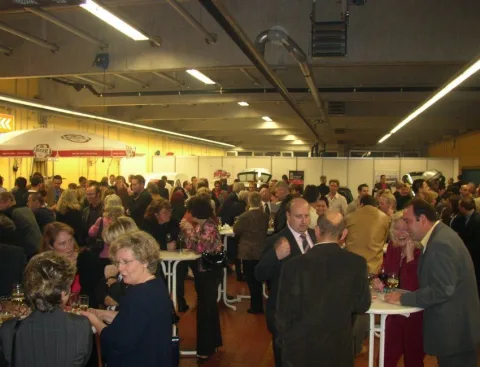 Voller Ausstellungsraum mit Gästen an Stehtischen