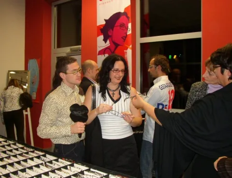 Besucherinnen vor einer roten Werbewand