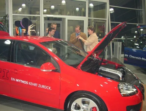 Ein roter Neuwagen mit geöffneter Haube