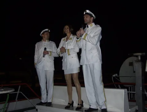 Drei Personen in weißen Uniformen an Deck