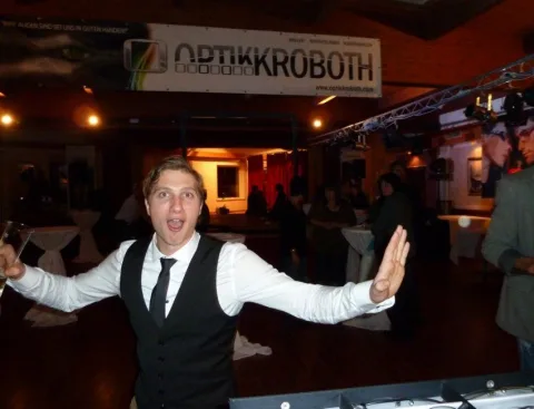 Ein Mann steht vor einem Schild mit der Aufschrift „Optikkroboth“